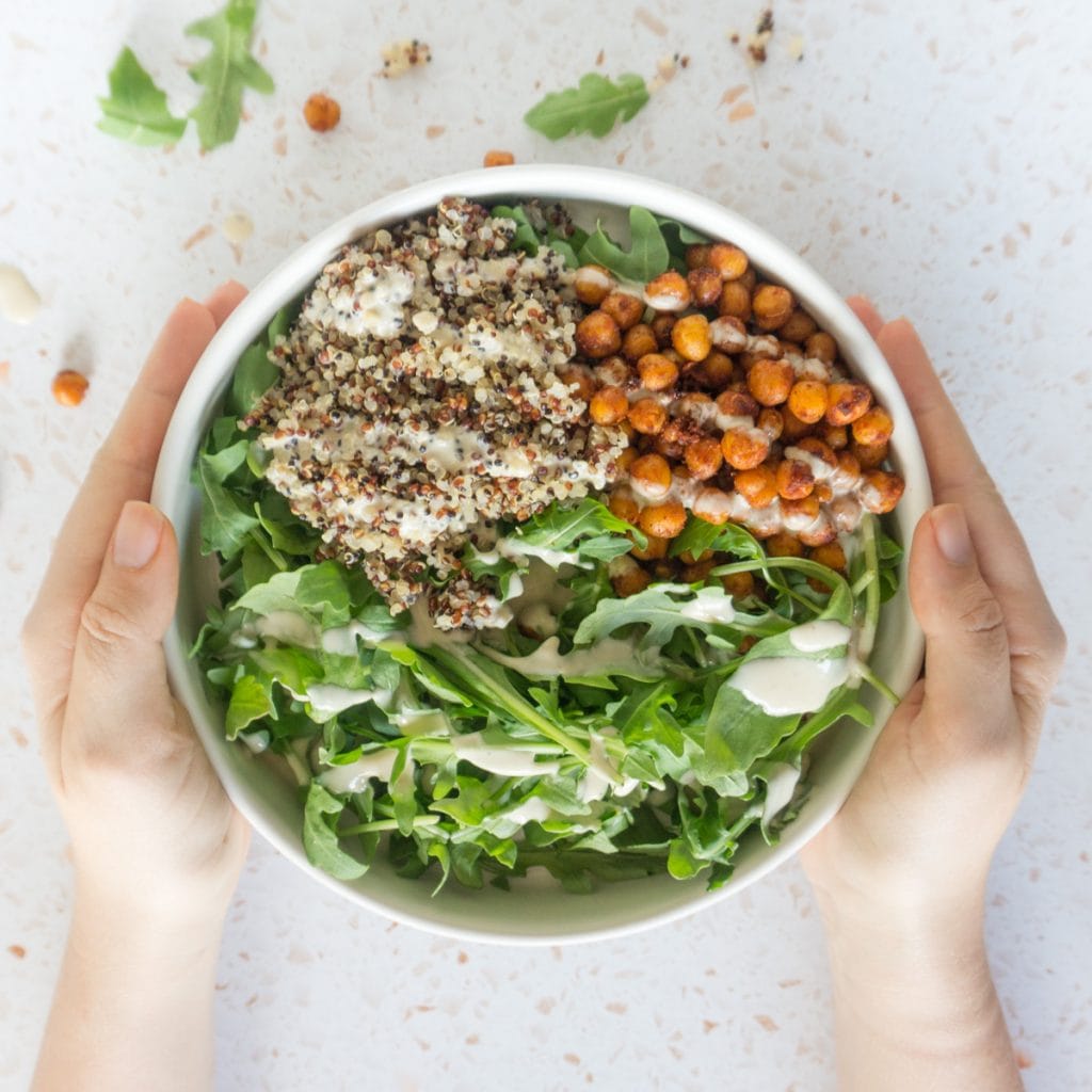 hands holding the chickpea bowls