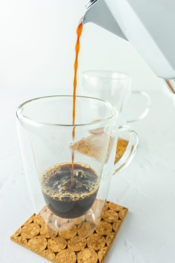 fresh espresso pouring into glass mug