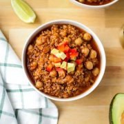 Bowl of chickpea quinoa stew topped with red pepper and avocado