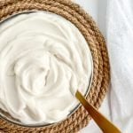 small glass bowl of vegan sour cream on a rope trivet