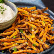 Plate of sweet potato fries with creamy dipping sauce.
