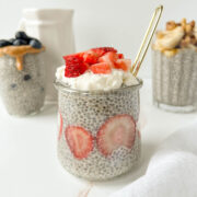 Close-up of chia pudding topped with fresh strawberries and whipped coconut cream.