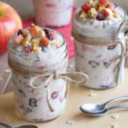 Two jars full of apple cinnamon overnight oats with apple toppings.