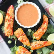 rice stuffed peppers with a cup od creamy peanut sauce.