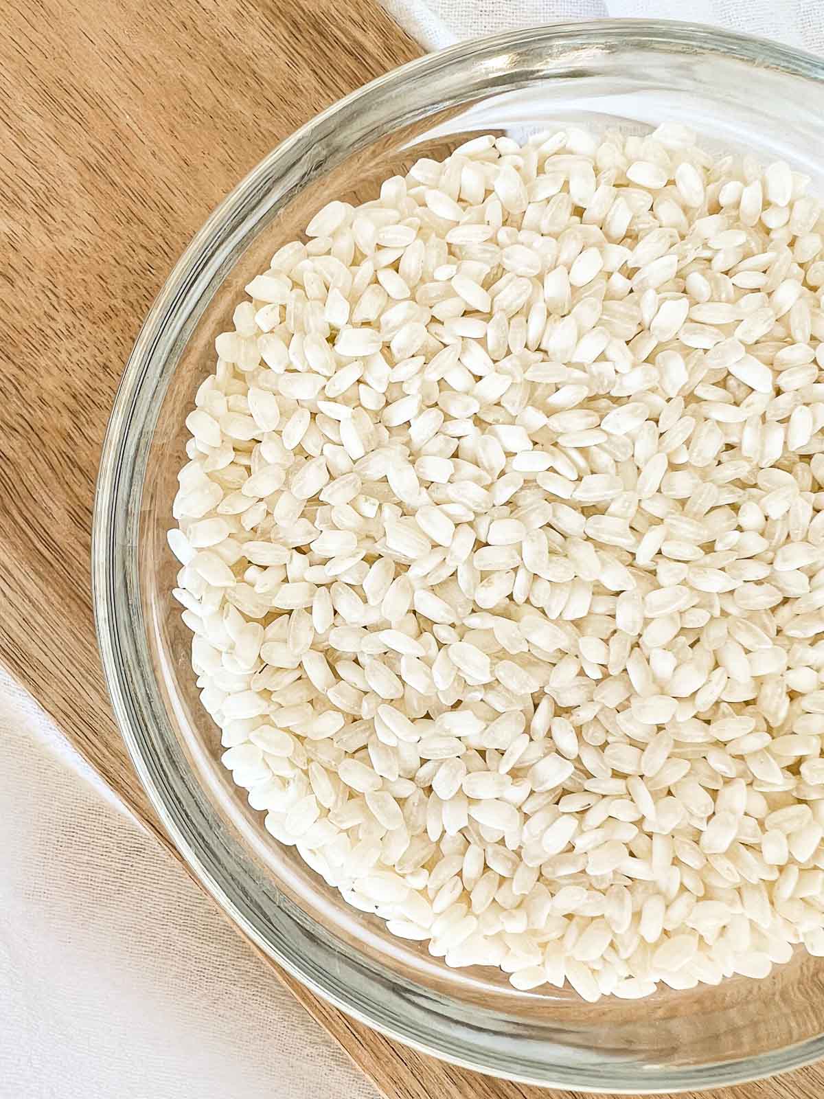 Dry arborio rice in a glass bowl.