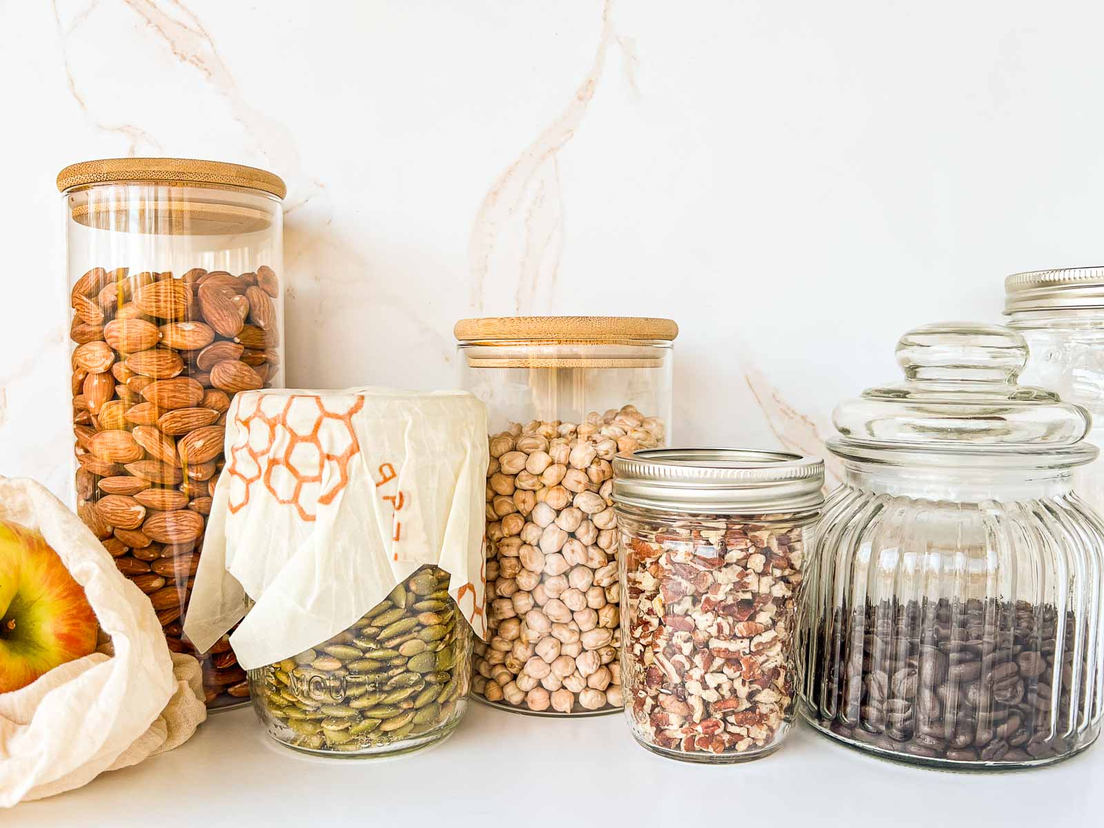 Several glass jars of different sizes filled with dry goods.