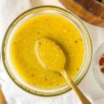 Vinaigrette in a bowl with a spoon sticking out.